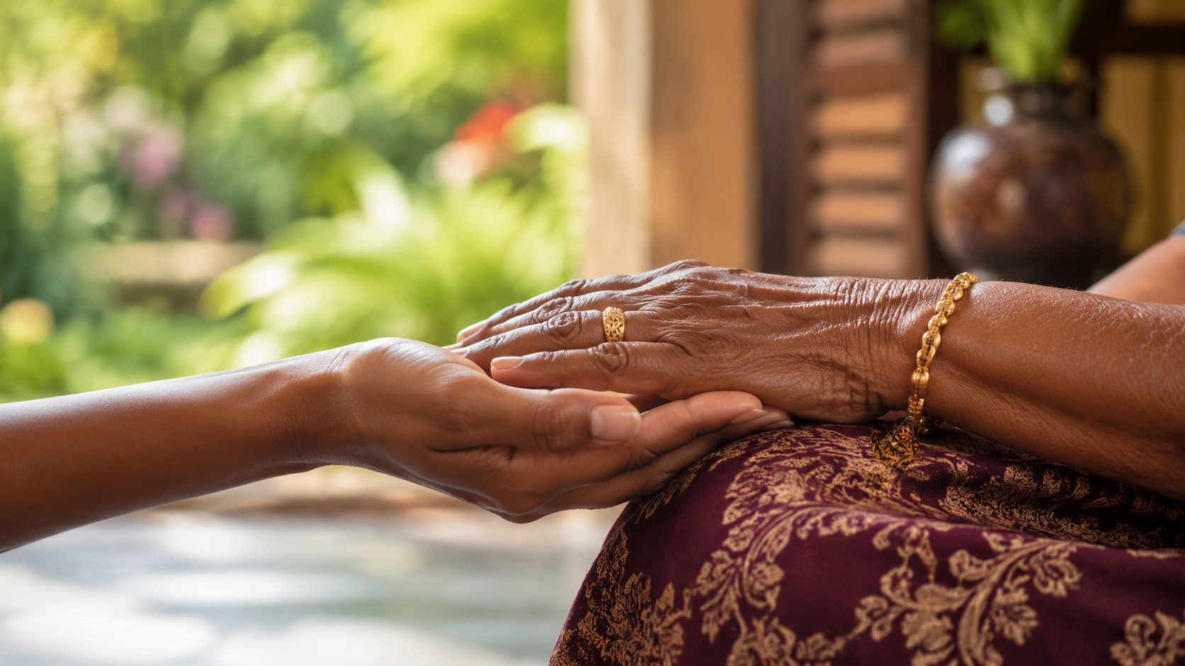 Een jongere hand ondersteunt liefdevol de hand van een oudere vrouw